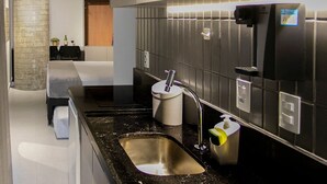 Una cocina moderna con encimera de granito negro, electrodomésticos de acero inoxidable y un microondas integrado.