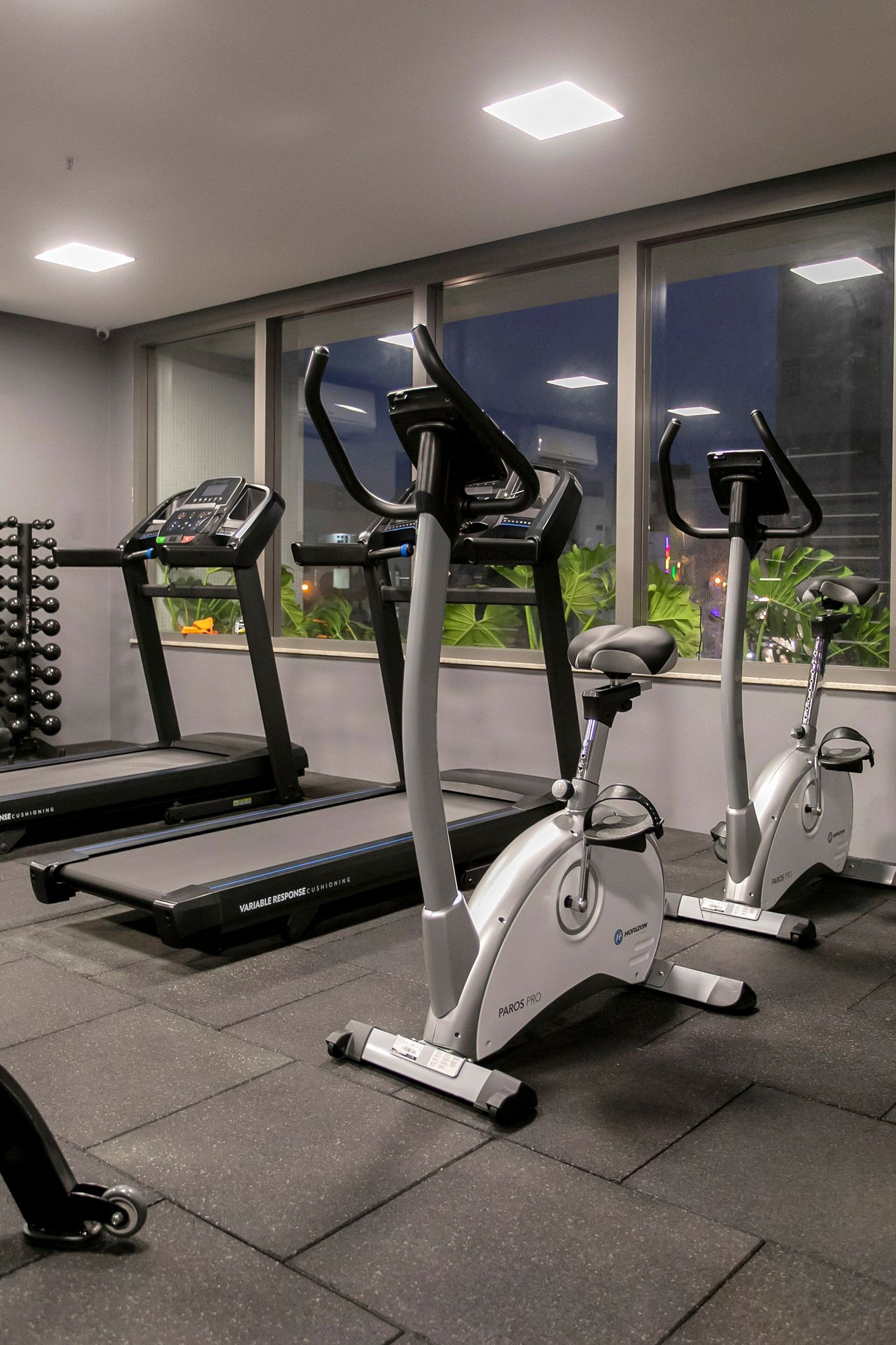 A gym with treadmills, an elliptical, and a weight bench.