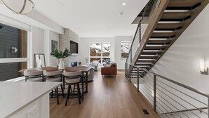 A modern kitchen with a dining area, a staircase, and a view of the outdoors. - Contemporary luxury in the heart of Silverthorne (Silverthorne)