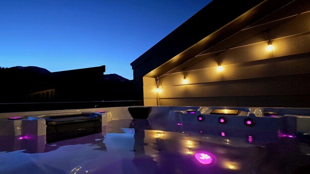 A modern outdoor hot tub area with built-in lighting and a reflective pool surface. - Contemporary luxury in the heart of Silverthorne (Silverthorne)