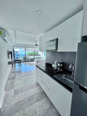 Fridge, microwave, coffee/tea maker, cookware/dishes/utensils