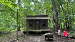 A rustic cabin with a front porch, a small deck, and a grill. - The Mill Creek Hideout (Mill Creek)
