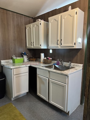 A kitchen with white cabinets, a sink, and a countertop. - The Mill Creek Hideout (Mill Creek)