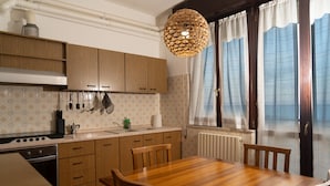A kitchen with wooden cabinets, a stove, and a dining table with chairs.