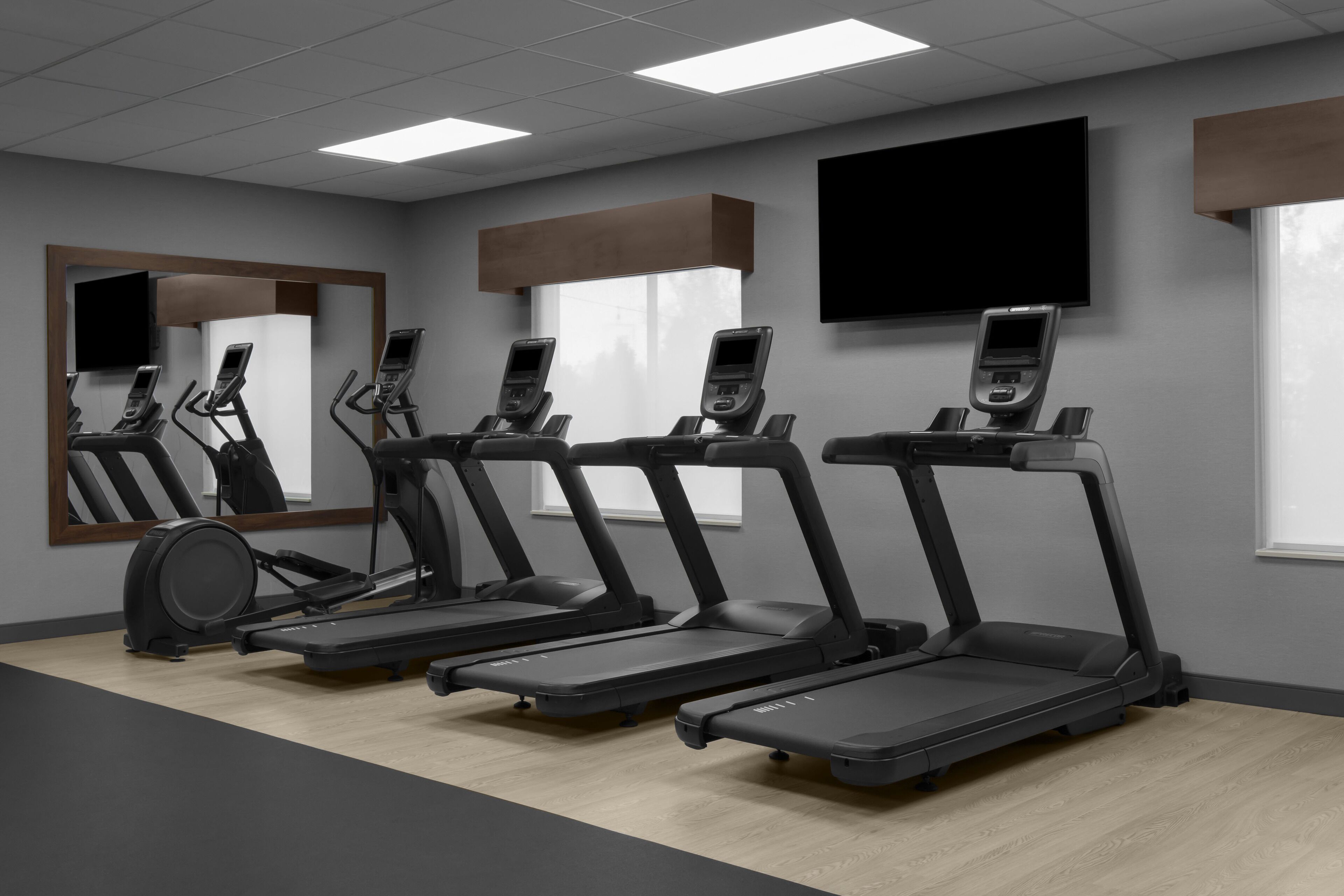 A gym with treadmills, a stationary bike, and a mirror.