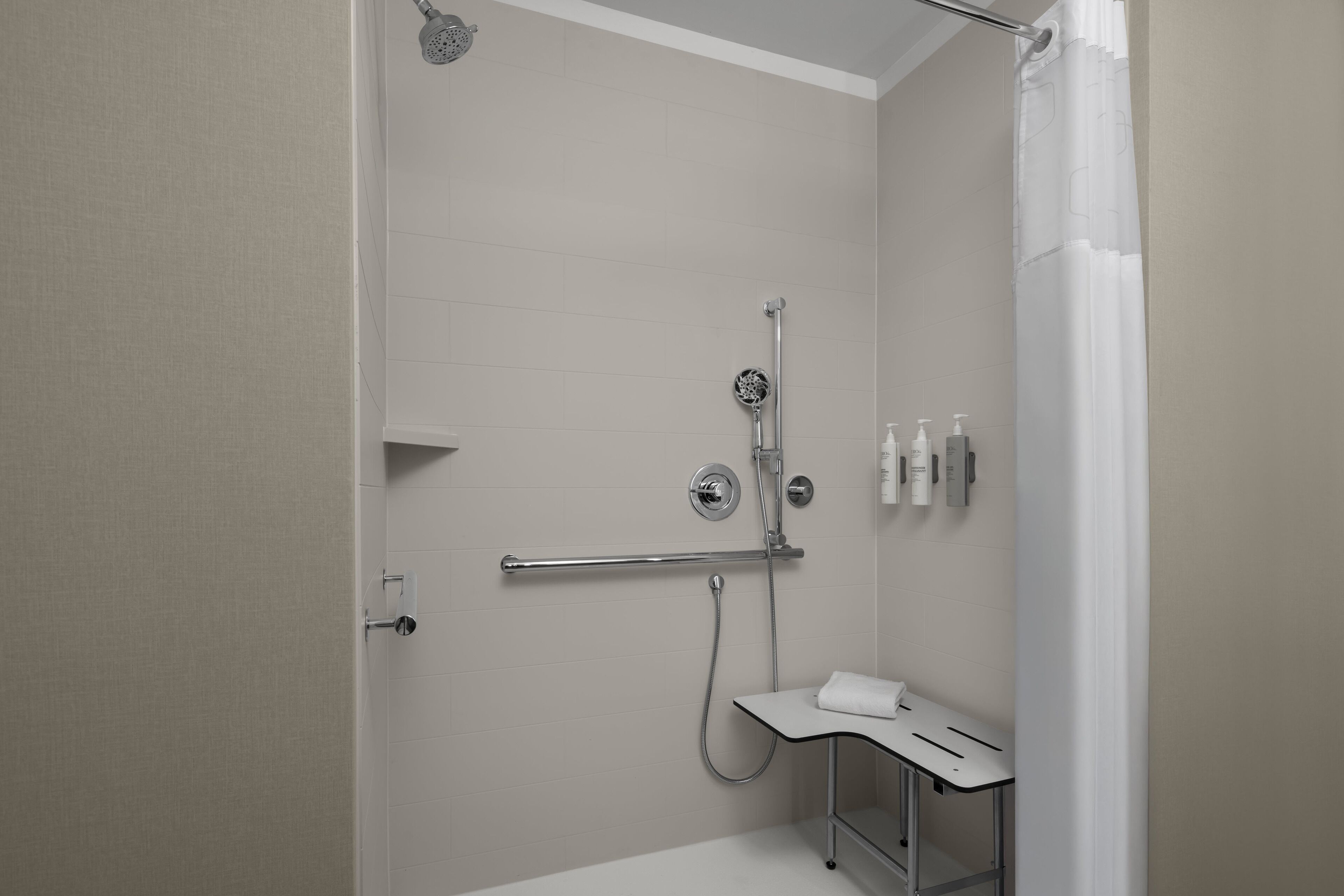 A modern bathroom with a shower, toilet, and sink.
