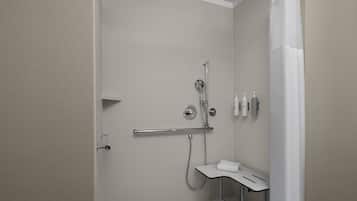 A modern bathroom with a shower, toilet, and sink.
