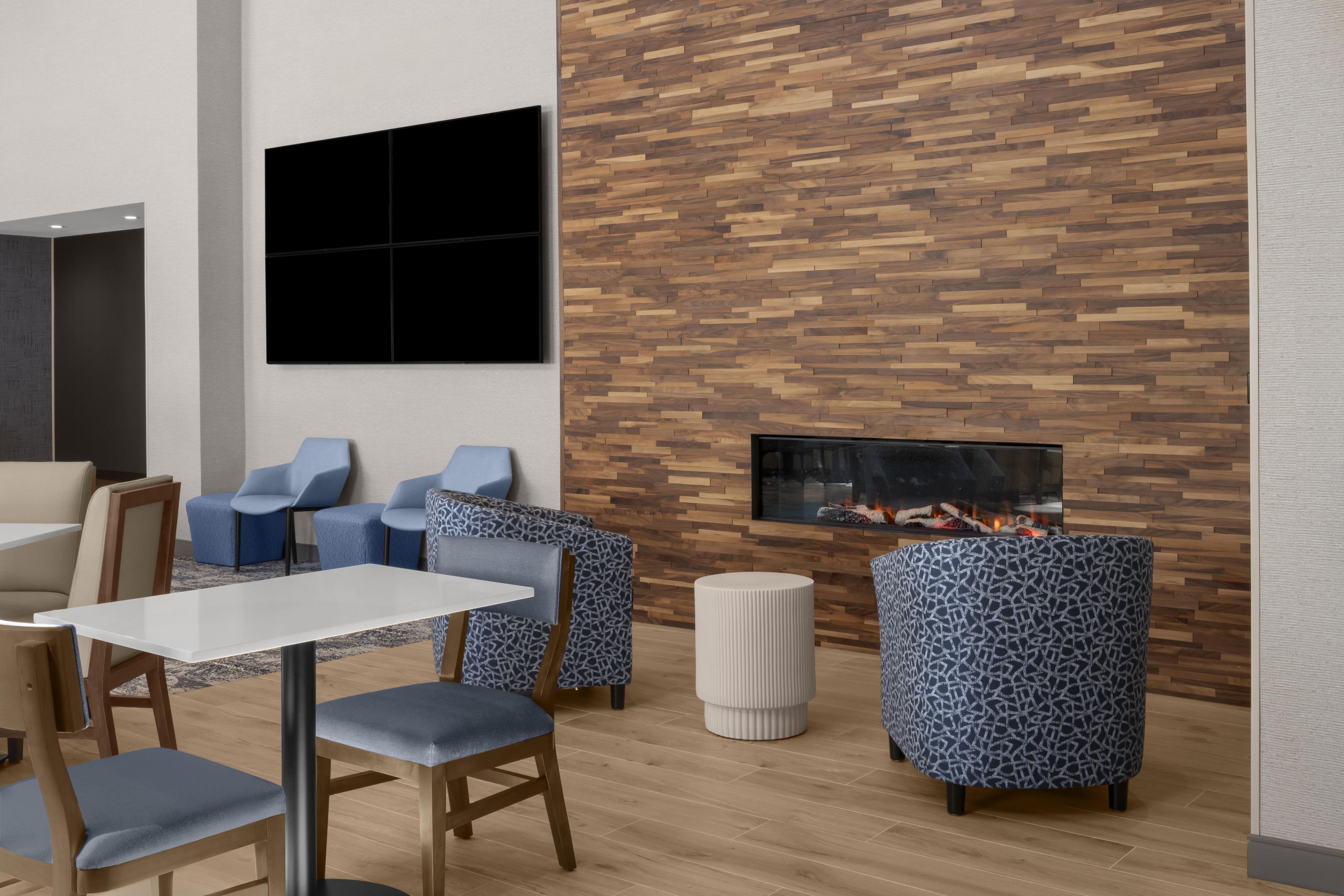 A modern interior with a wooden wall, seating area, and a fireplace.