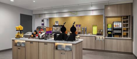 A modern self-service coffee station with multiple coffee machines, a display of coffee beans, and a variety of condiments.
