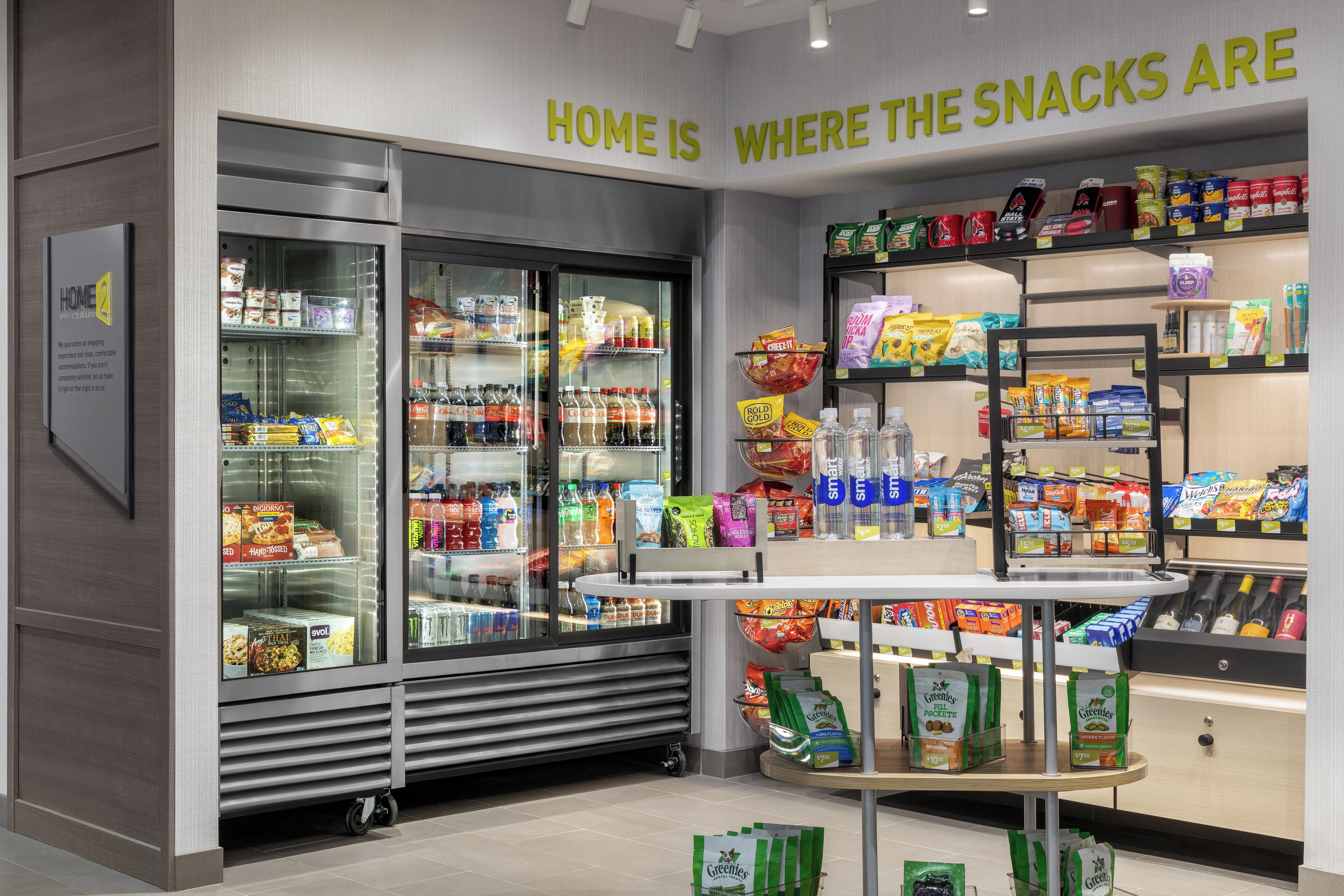 Una sección de productos para picar en una tienda, con mostradores refrigerados y estantes.