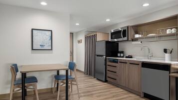 Una cocina moderna con comedor, electrodomésticos de acero inoxidable y un mapa en la pared.
