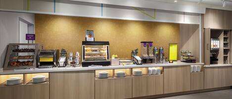 A modern breakfast bar with a variety of food items and a self-service station.