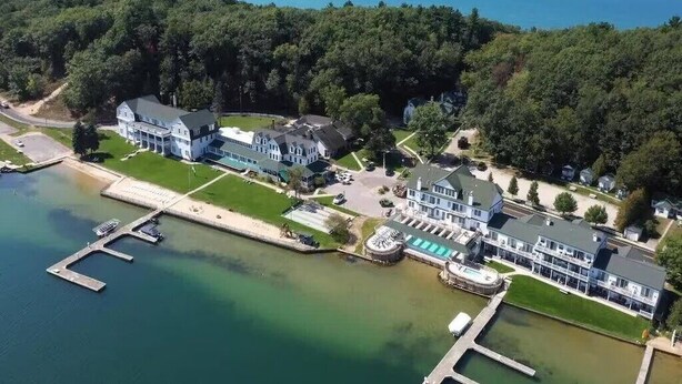 A large waterfront property with multiple buildings, a dock, and a marina. - Lakefront 1 bdrm—Pool & Hot Tub—Lake Michigan Access—2 Kayaks Provided! (Onekama)