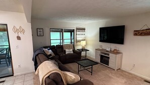 A living room with a sectional sofa, a coffee table, a TV, and a fireplace. - Woodson Bend 3 BR Condo 82-4, with  AC, WiFi, Pool, Golf Course, Restaurant (Bronston)