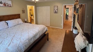 A bedroom with a bed, a ceiling fan, a door, and a hallway leading to another room. - Woodson Bend 3 BR Condo 82-4, with  AC, WiFi, Pool, Golf Course, Restaurant (Bronston)