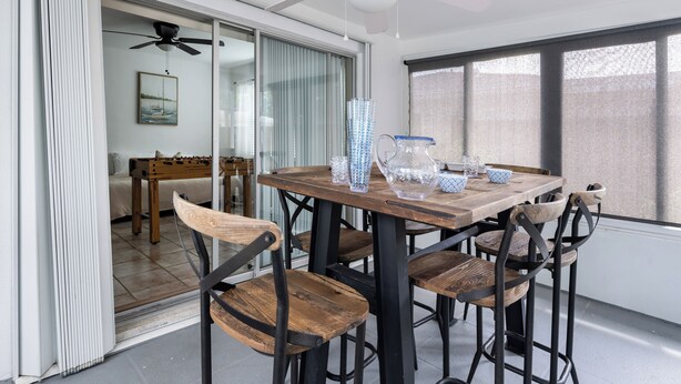 A dining area with a wooden table, metal chairs, and a ceiling fan.