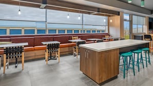 Un restaurant moderne avec des tables hautes, des banquettes et un espace bar.