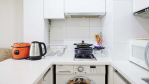 A compact kitchen with a washing machine, a microwave, a kettle, and a slow cooker. - Super and affordable condo in Gangnam offering a boutique hotelstyle experience! (Seoul)