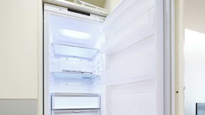 An open refrigerator with multiple shelves and a freezer compartment. - Super and affordable condo in Gangnam offering a boutique hotelstyle experience! (Seoul)