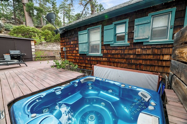 Puinen mökki, jossa on poreallas, terassi ja satelliittiantenni.
