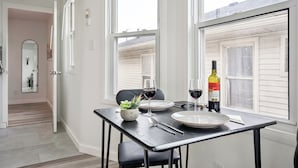 A dining area with a table set for two, a wine bottle, and a glass of red wine. - 15 min. to Detroit center - bathroom with floor heating - free curbside parking (River Rouge)