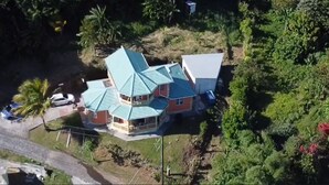 Una casa con techo verde y un pequeño porche.