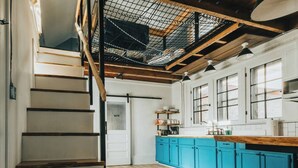 A kitchen with blue cabinets, a wooden countertop, and a visible door labeled "BATH". - The Banana Hammock (Logan)