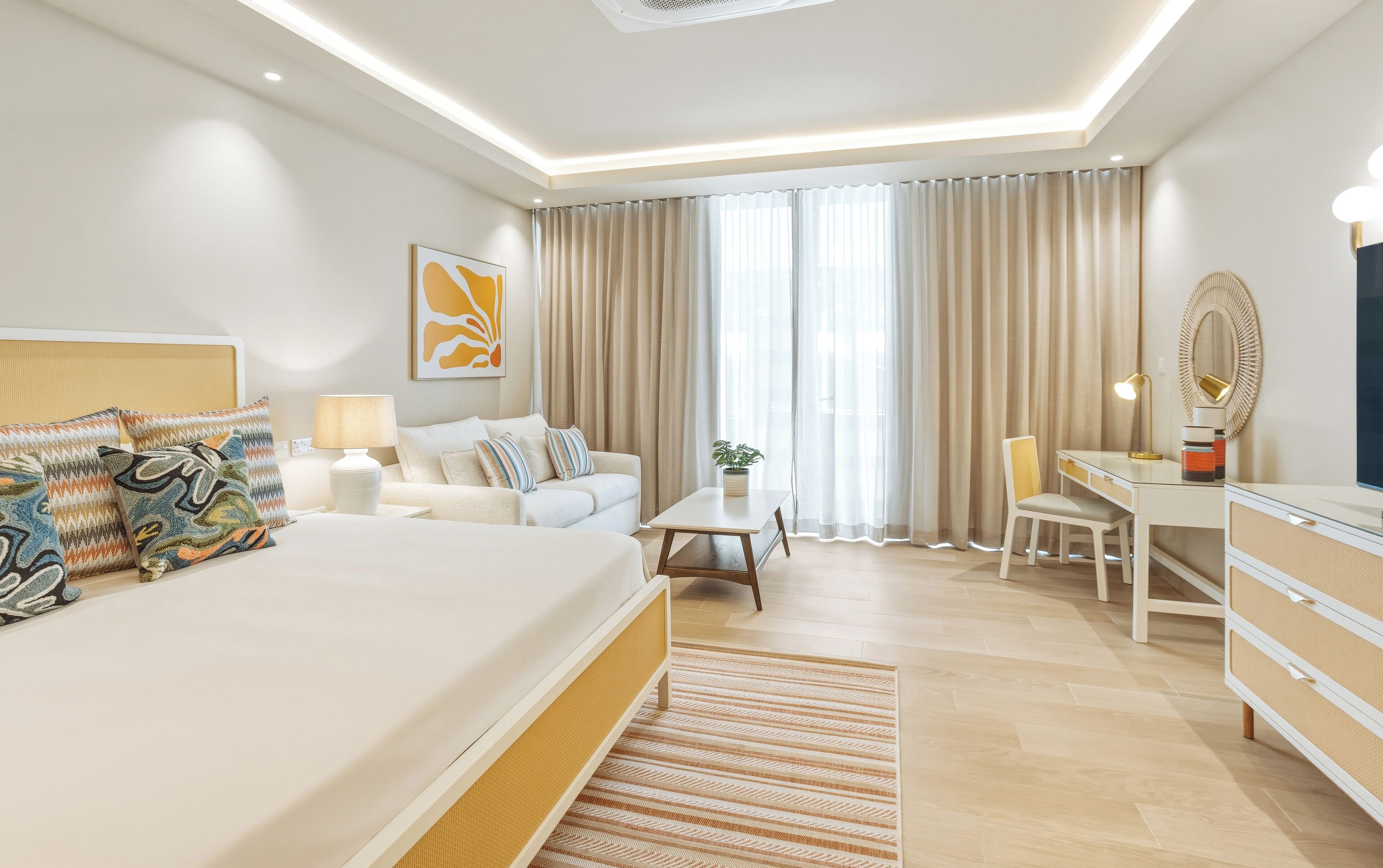 Ein modernes Hotelzimmer mit einem großen Bett, einem Schreibtisch, einem Sessel, einer Lampe und einer Topfpflanze.