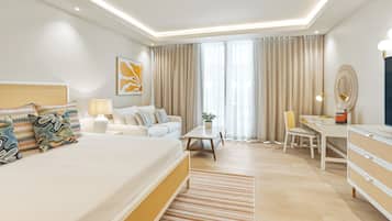 Ein modernes Hotelzimmer mit einem großen Bett, einem Schreibtisch, einem Sessel, einer Lampe und einer Topfpflanze.