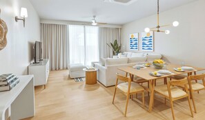 Ein modernes Wohnzimmer mit Essbereich, einem Fernseher und einem Deckenventilator.