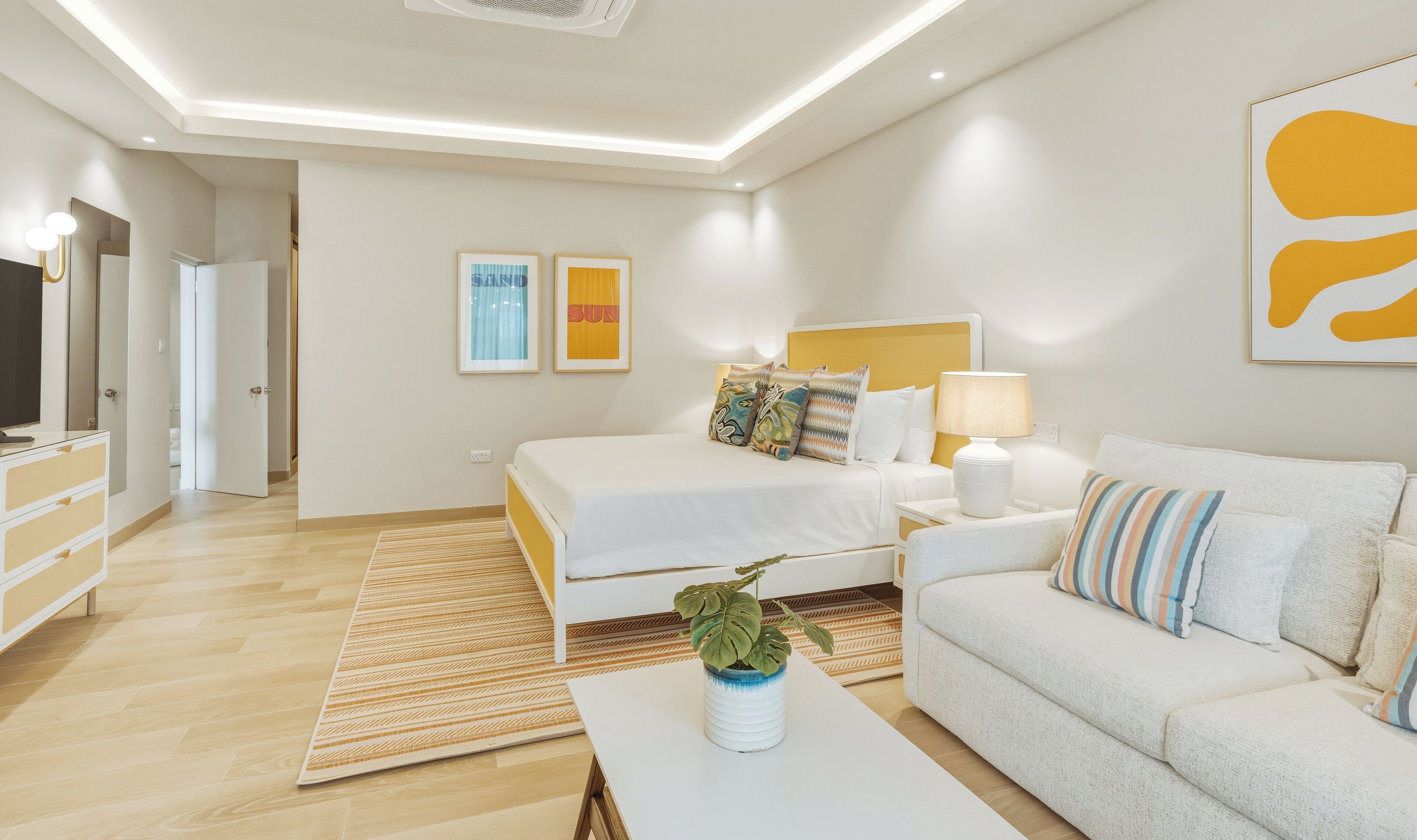 Ein modernes Schlafzimmer mit Bett, Nachttisch, Lampe und einer Couch.