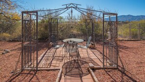 A metal gazebo with a table and chairs in a desert setting. - Charming 3-bedroom house with AC, WiFi in tranquil Cottonwood (Cottonwood)