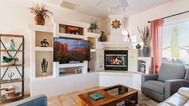 A living room with a fireplace, a television, and a sofa. - Charming 3-bedroom house with AC, WiFi in tranquil Cottonwood (Cottonwood)