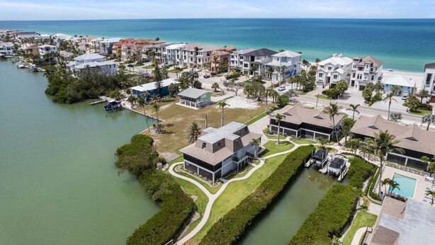 Zona residencial costera con casas, un puerto deportivo y vista despejada del océano.