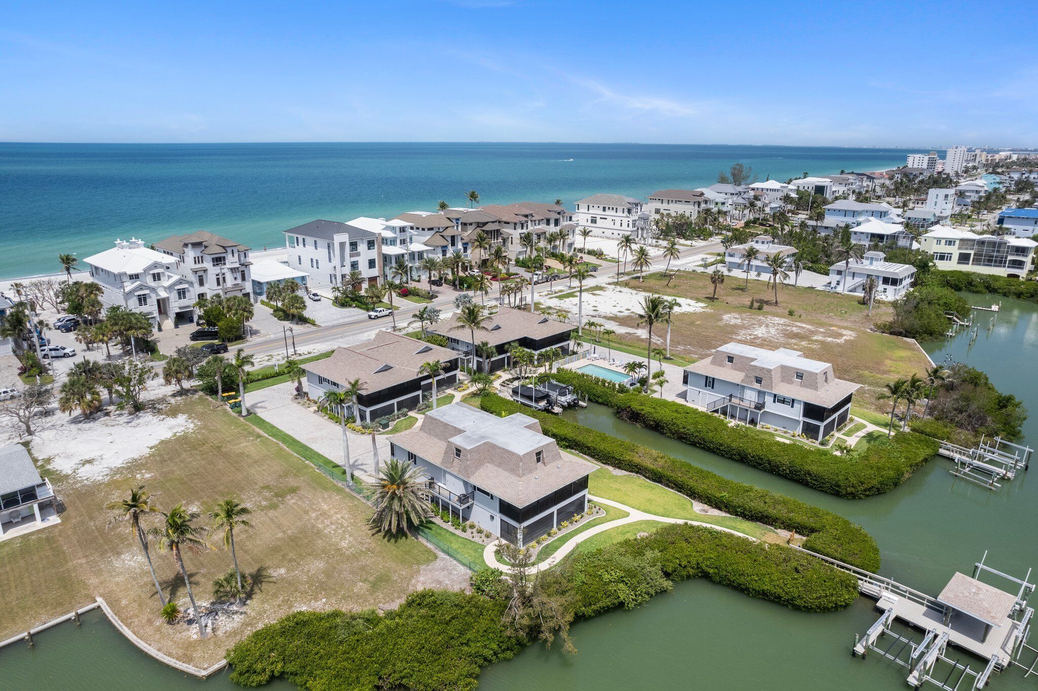 Un quartier résidentiel en bord de mer, avec des maisons, un port de plaisance et une vue dégagée sur l’océan.
