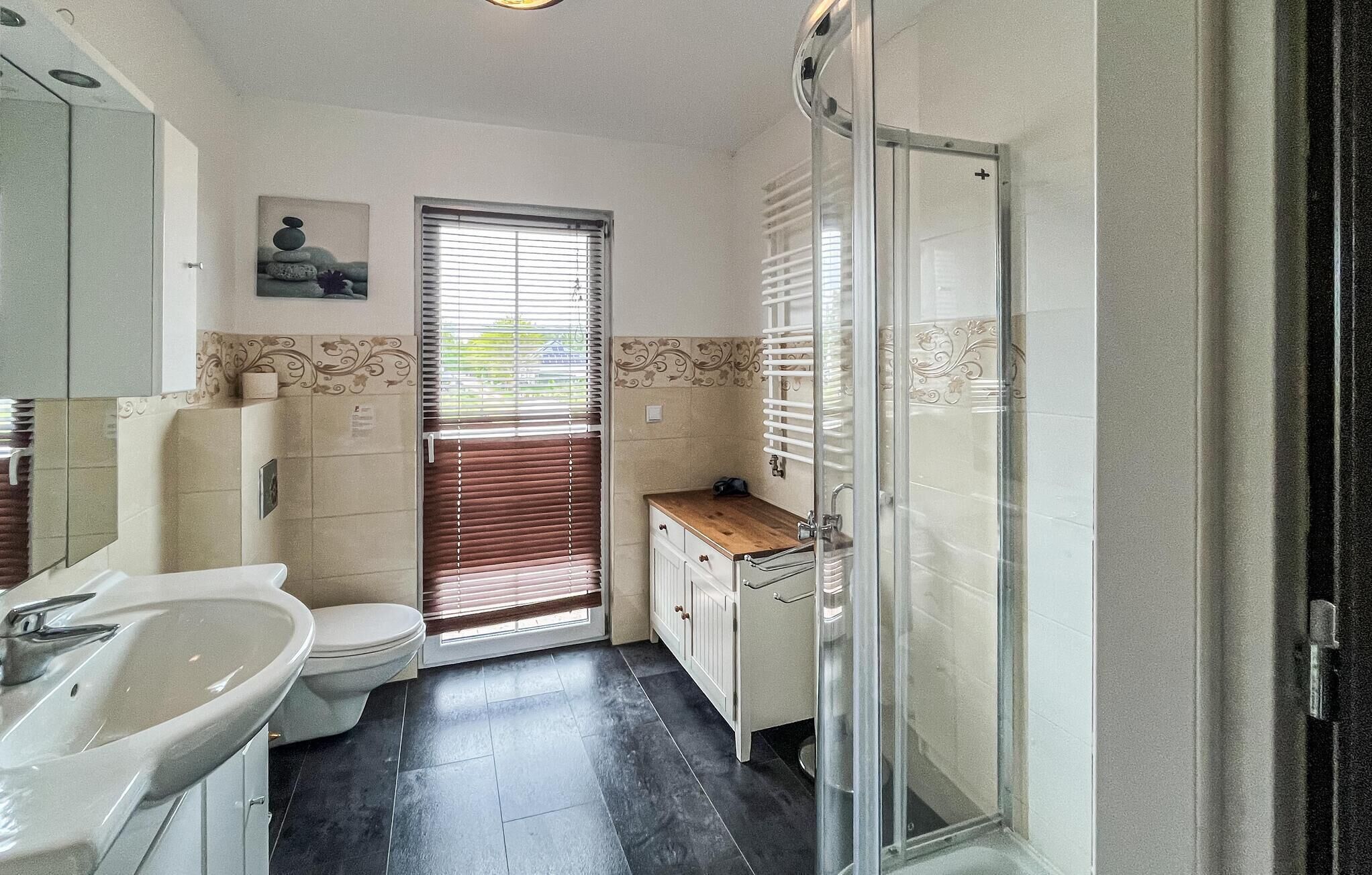 Une salle de bain avec des toilettes, un lavabo et une douche.