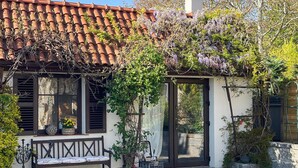Un bâtiment traditionnel avec un toit en tuiles, un banc et une porte.