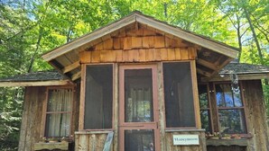 Una cabaña de madera con un porche, una puerta y un letrero que dice 'Honeymoon'.