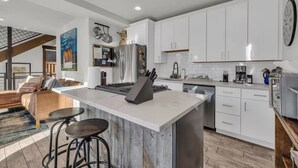 A modern kitchen with white cabinets, a marble island, and stainless steel appliances. - Dual-Unit Mountain Retreat: 4BR,  Prime Location, Sleeps 10, Historic Charm & Modern Luxury, Steps to Main St! (Park City)