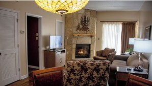 Una sala de estar con chimenea, televisor y comedor con mesa y sillas.