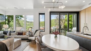 Una cocina moderna con comedor, ventanas amplias y vistas al exterior.