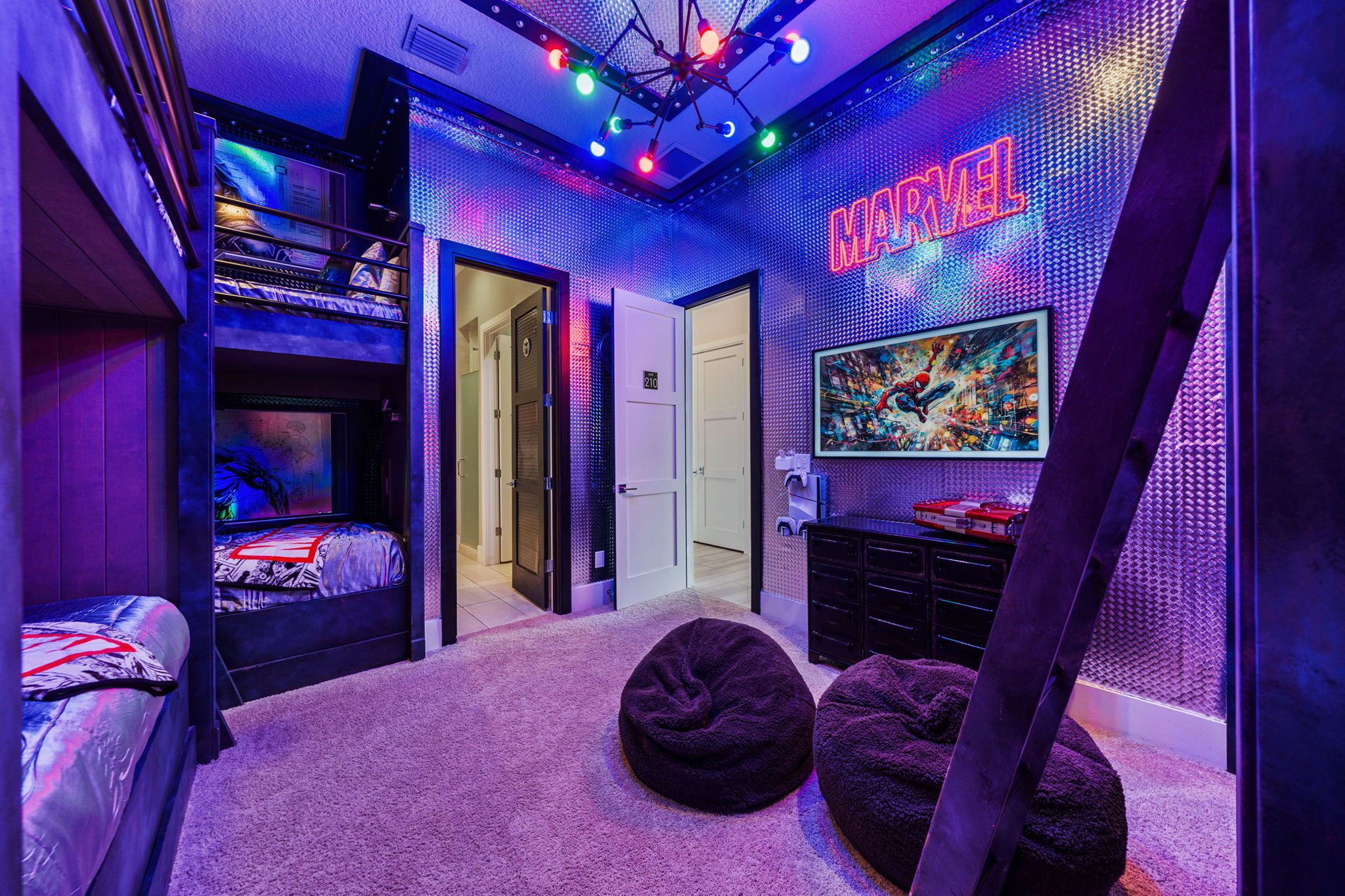 A room with bunk beds, a bean bag, a Marvel-themed wall, and a door leading to another room.