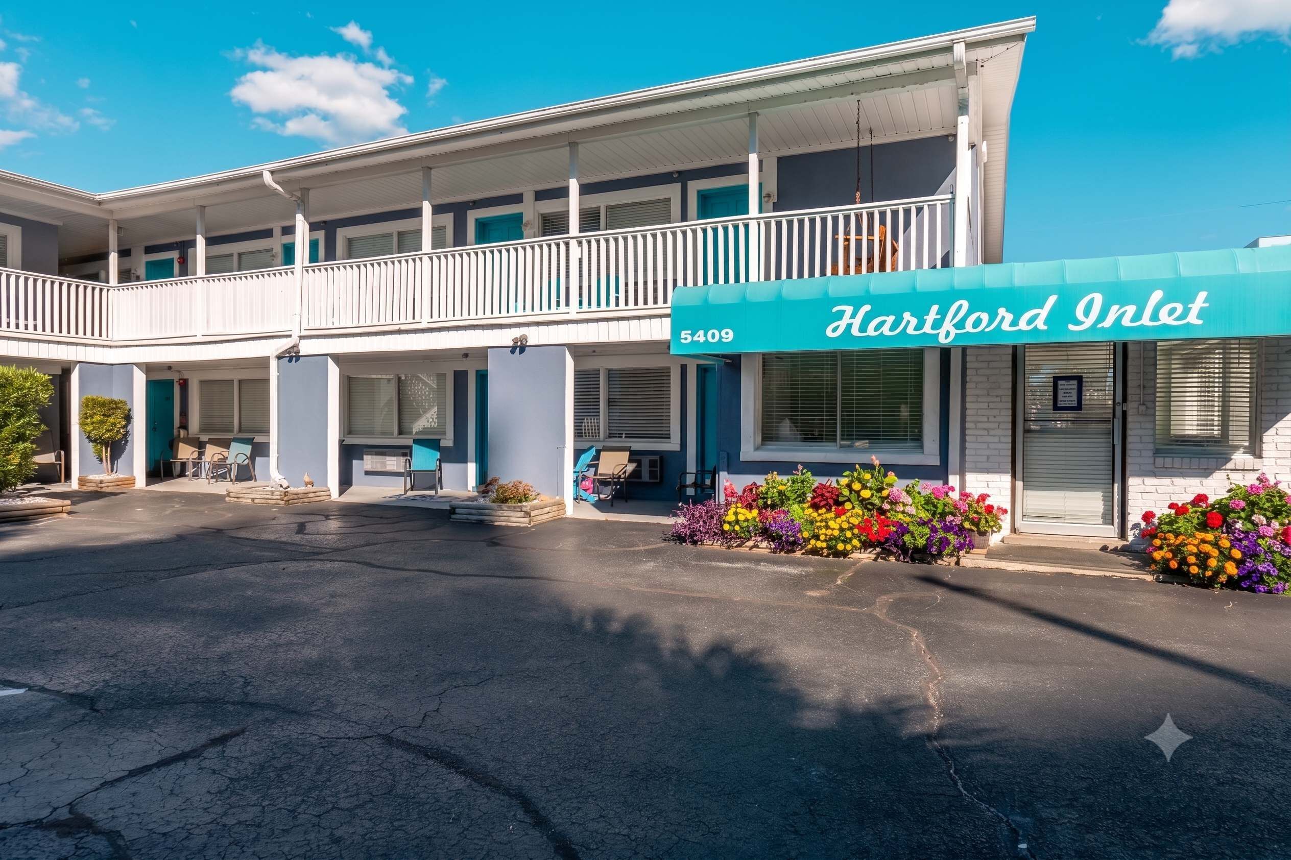 A motel with a two-story structure, a balcony, and a sign reading 'Hartford Inlet 5409.'
