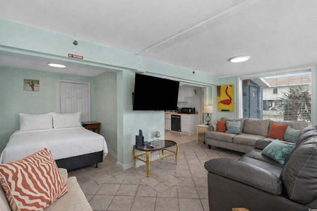 A hotel room with a bed, a sofa, a TV, a small table, and a kitchen area.. Hartford Inlet 100