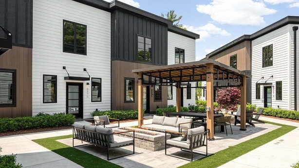Un patio exterior moderno con un área de estar y una estructura de pérgola.