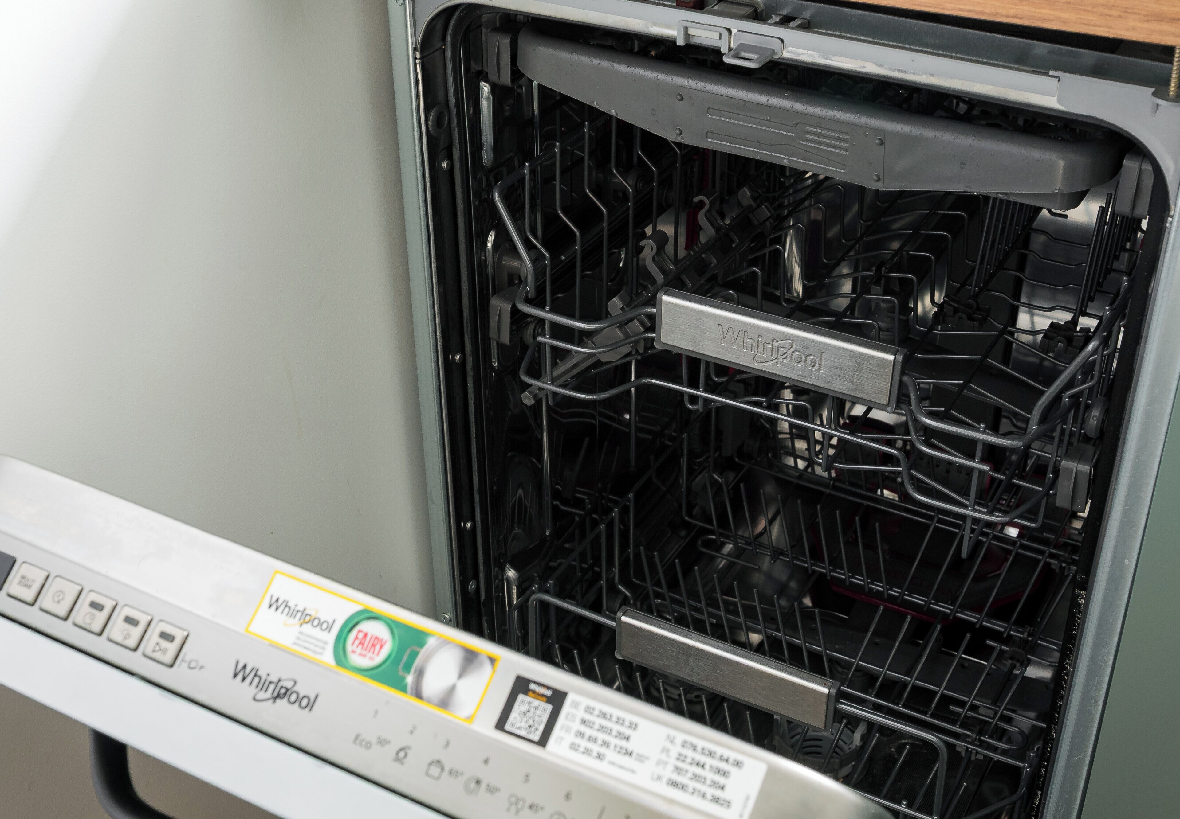 Lavastoviglie aperta con pannello comandi e indicazione del marchio Whirlpool.