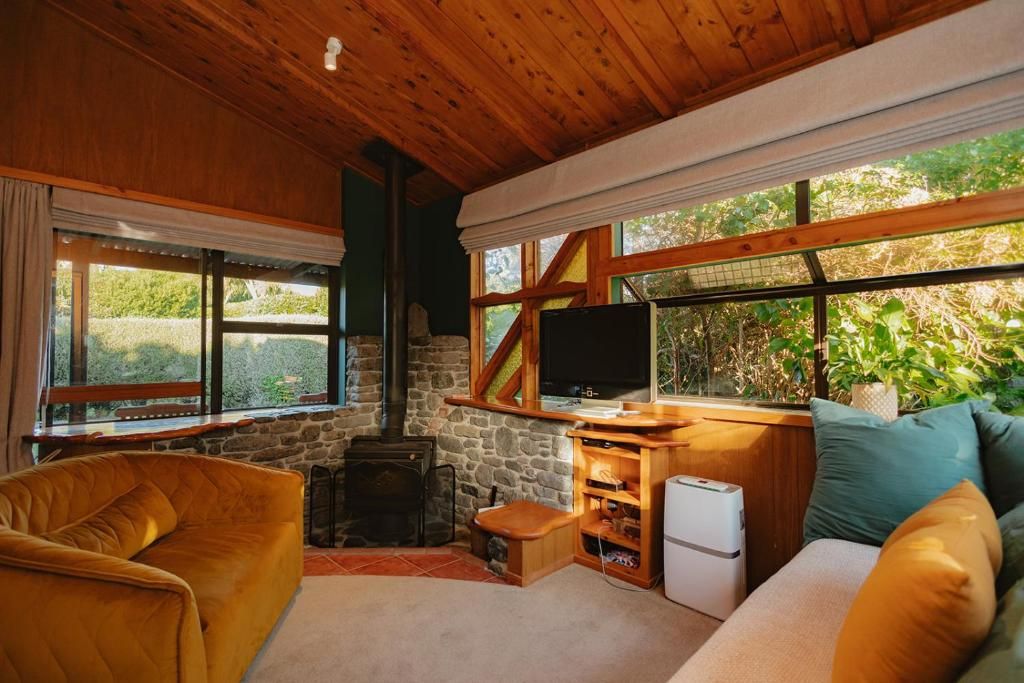 Ein gemütliches Zimmer mit Kamin, Fernseher und einer Couch.