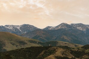 A mountainous landscape with snow-capped peaks and rolling hills. - Mangamaunu Cottage, The Mangamaunu Cottage (Hapuku)
