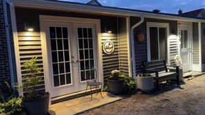 A house with a front porch, a bench, and potted plants. - Soothing Carriage House with Hot Tub in charming Stratford (Stratford)