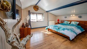 A bedroom with a wooden bed, a large window, and a rustic decor.